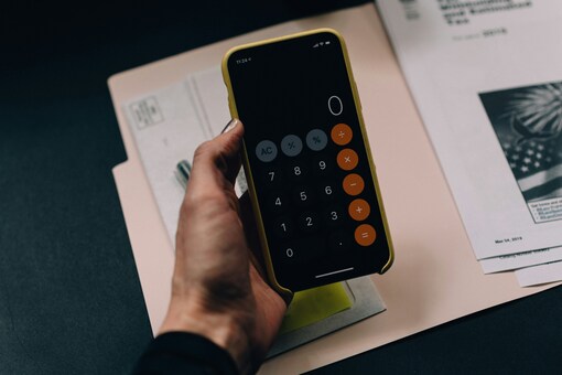 A HAND HOLDING A PHONE CALCULATOR FROM UNSPLASH