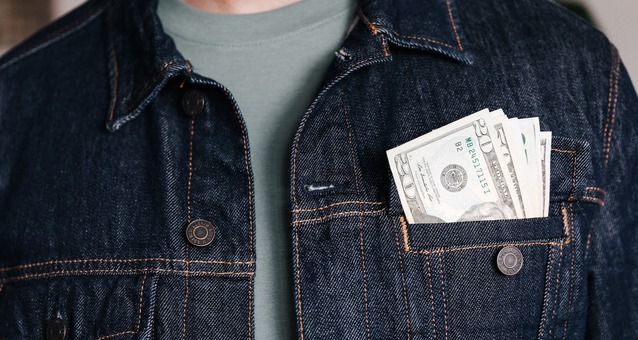 Money in the pocket of a denim jacket